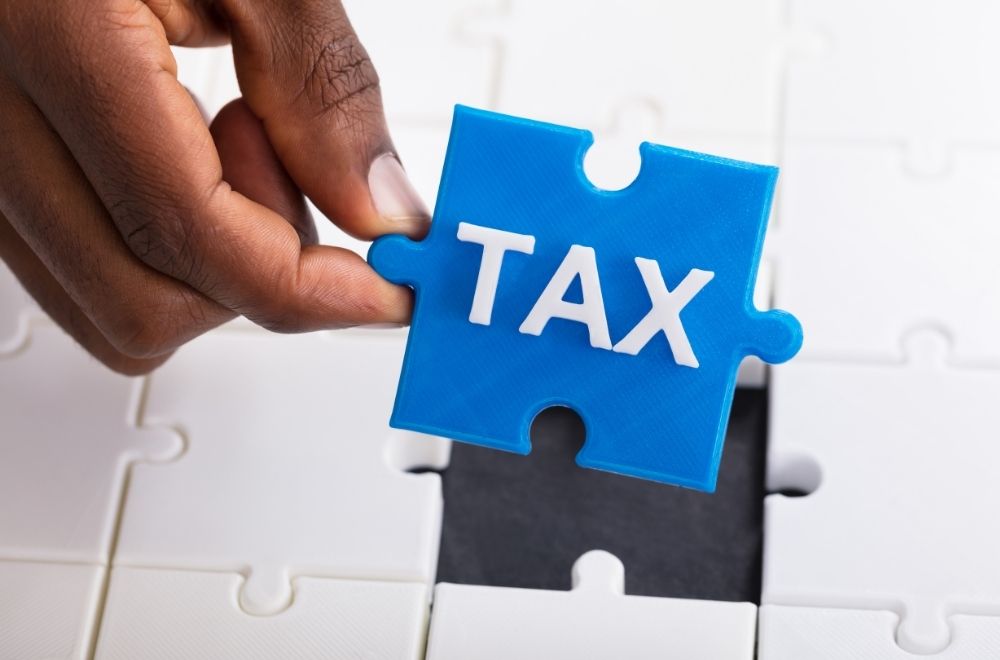 Hand Holding Tax Puzzle Piece