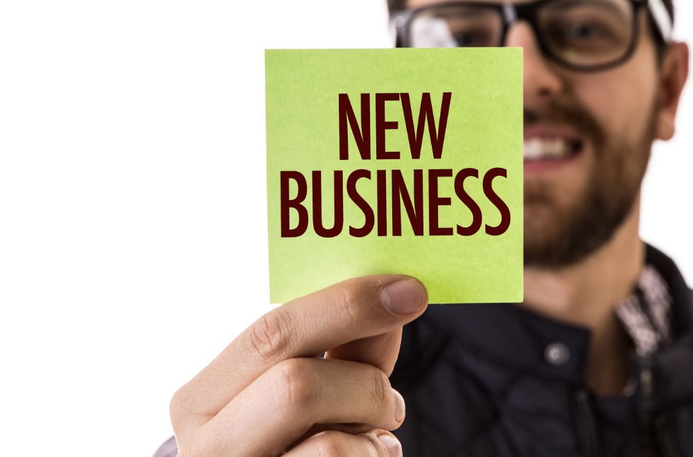 Man Holding Post It Note Reading &quot;New Business&quot;