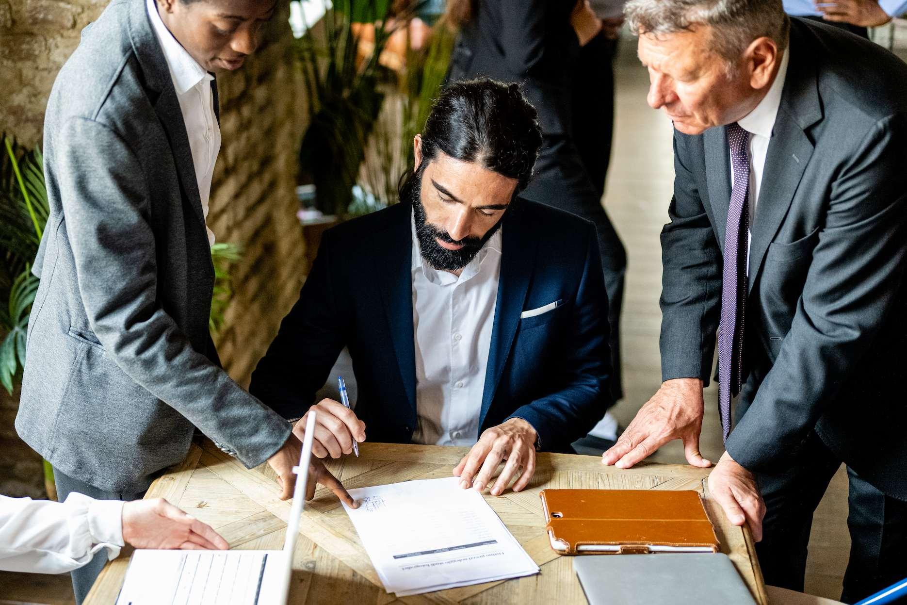 A well-dressed entrepreneur signing documents for UAE residence visa application and Dubai business setup in DUQE free zone.