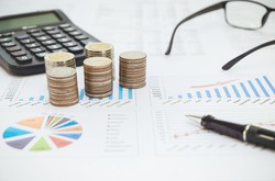 Accounting Paperwork And Calculator With Coins And Glasses On Desk