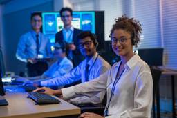 Software support team working at computer stations in a modern technology office.