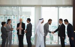 International business leaders discussing a UAE holding company structure in Dubai.