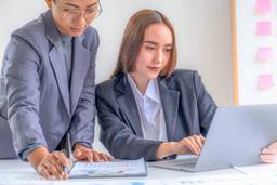 Business professionals analysing UAE holding company tax and financial data.