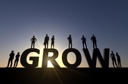 The Word Grow With Business People Standing On The Letters