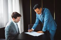Founders signing business partnership documents for a Dubai free zone company.